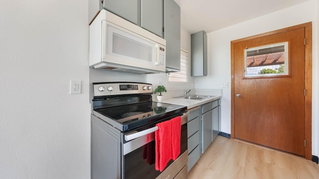 kitchen featuring gray cabinets, stainless steel range with electric cooktop, a wealth of natural light, and sink