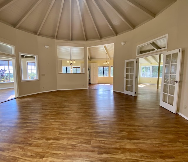 unfurnished living room featuring french doors, high vaulted ceiling, hardwood / wood-style floors, and beamed ceiling