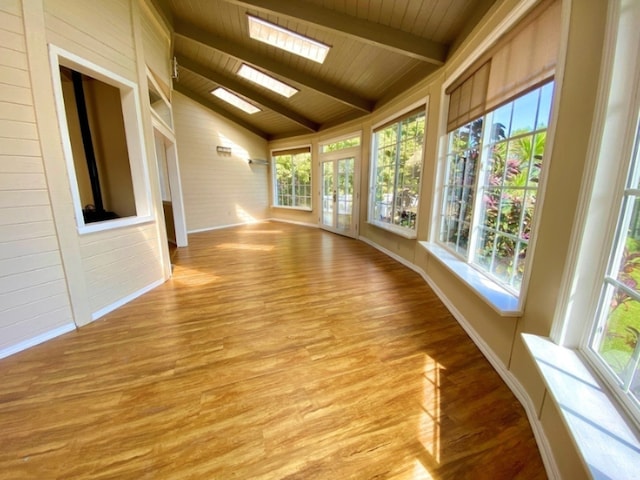 unfurnished sunroom featuring vaulted ceiling with skylight and wood ceiling