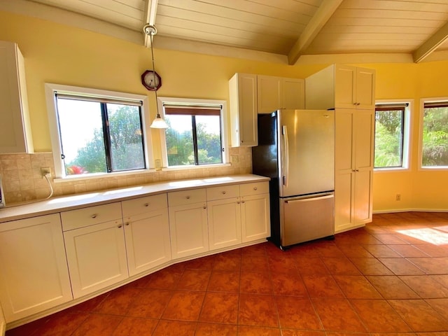 kitchen featuring white cabinets, pendant lighting, stainless steel fridge, and decorative backsplash