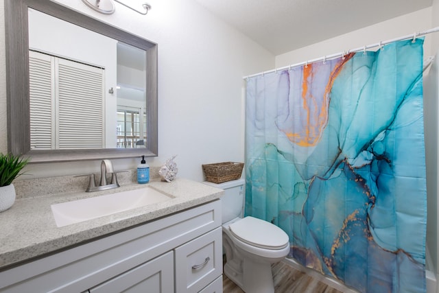 full bath featuring toilet, curtained shower, wood finished floors, and vanity