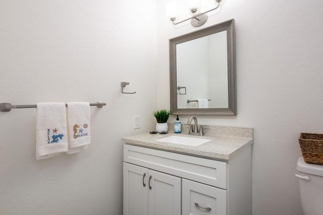 half bathroom featuring vanity and toilet