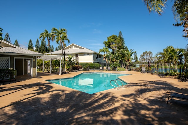 pool with fence, a patio, and a pergola