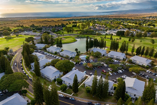 aerial view at dusk with a residential view and a water view