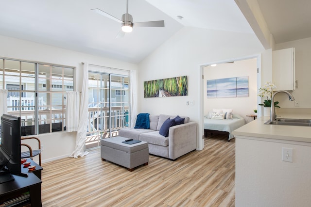 living room with vaulted ceiling, ceiling fan, and light wood-type flooring