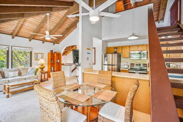 carpeted dining space with high vaulted ceiling, beamed ceiling, wooden ceiling, and a ceiling fan