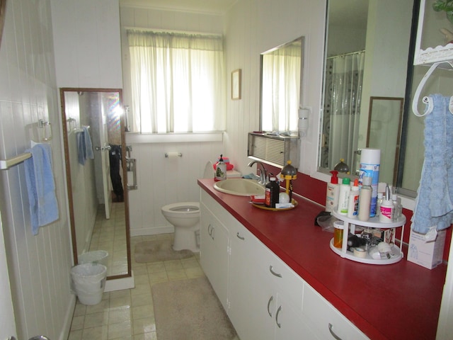 bathroom with toilet, tile patterned flooring, a shower stall, and vanity