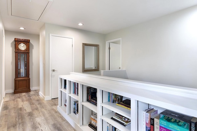 hall featuring light wood-type flooring, attic access, baseboards, and recessed lighting