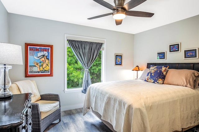 bedroom featuring wood finished floors, a ceiling fan, and baseboards