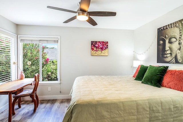 bedroom with a ceiling fan, baseboards, and wood finished floors