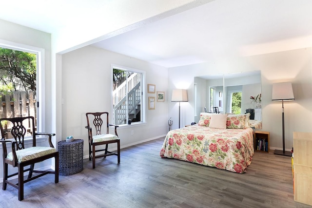 bedroom with dark wood-type flooring, multiple windows, and baseboards