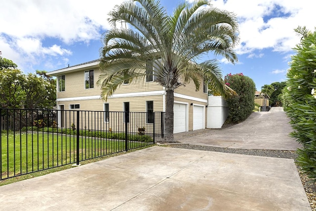 view of side of property featuring a yard, concrete driveway, and fence