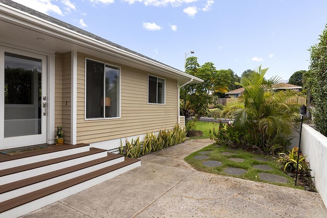 view of property exterior with a patio area and fence