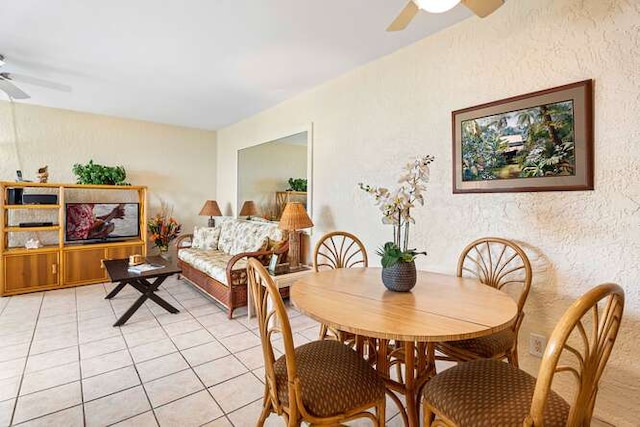 dining space with a ceiling fan and light tile patterned flooring