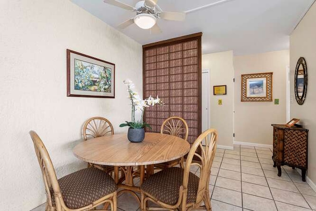 dining space featuring light tile patterned floors, ceiling fan, and baseboards