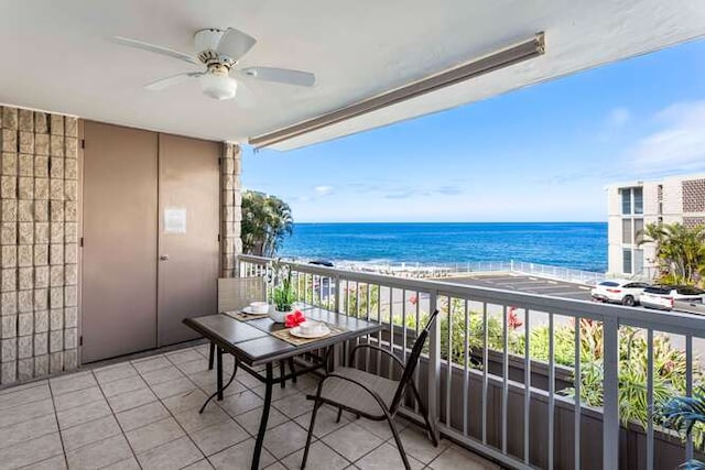 balcony with a water view, a ceiling fan, and a view of the beach