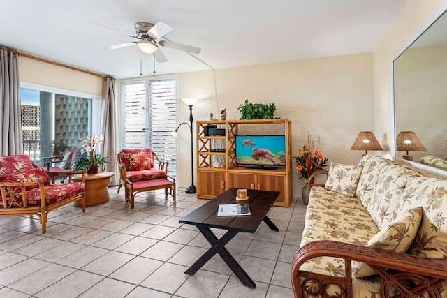 living area with light tile patterned floors, a ceiling fan, and a wealth of natural light