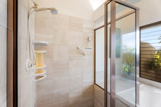 bathroom with a stall shower and a tub