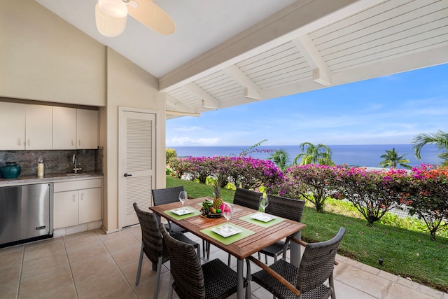 exterior space featuring a water view, outdoor dining area, and a sink