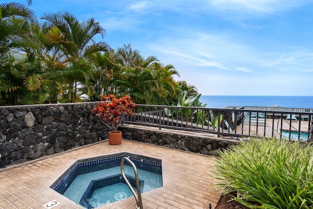 view of swimming pool featuring a community hot tub and a water view