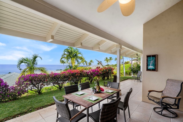 view of patio with a ceiling fan, outdoor dining area, and a water view