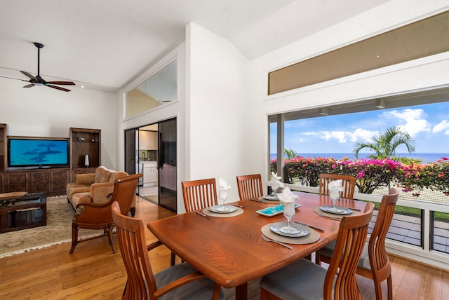 dining area with a high ceiling, hardwood / wood-style flooring, and a ceiling fan