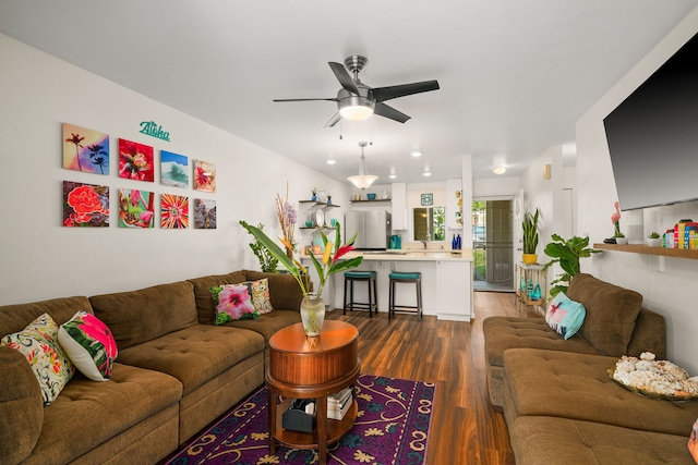 living area with a ceiling fan and dark wood-type flooring