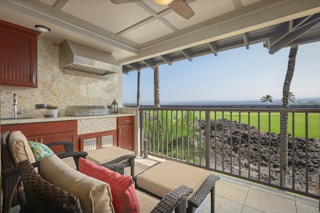 balcony with grilling area, a ceiling fan, an outdoor kitchen, and a sink