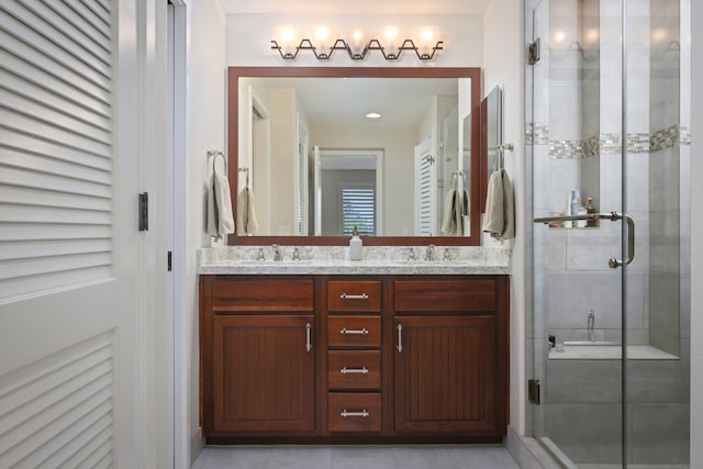 bathroom featuring a stall shower, a sink, and double vanity