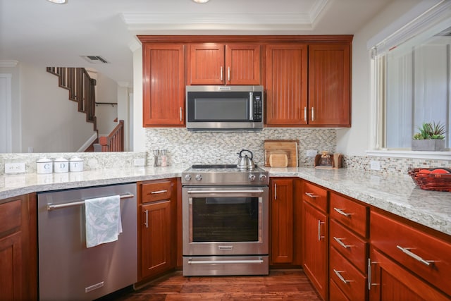 kitchen featuring light stone countertops, tasteful backsplash, stainless steel appliances, and dark wood-type flooring