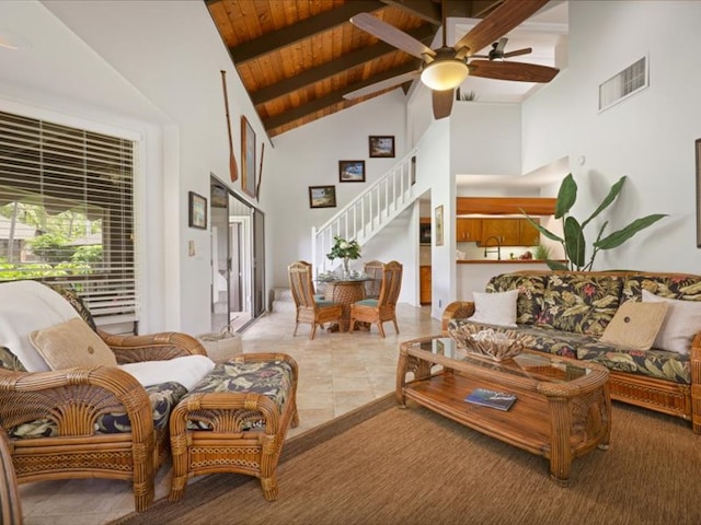 living area featuring visible vents, beam ceiling, a ceiling fan, stairway, and wood ceiling