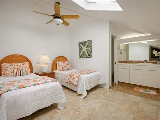 bedroom featuring ceiling fan, lofted ceiling with skylight, and a sink