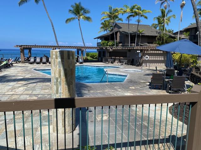 pool featuring a patio and a water view