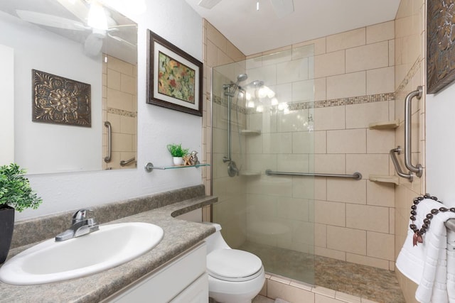 full bathroom with a ceiling fan, tiled shower, vanity, and toilet