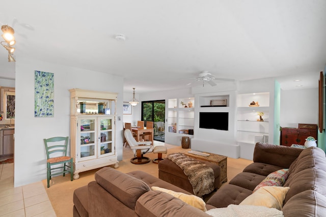 living area featuring built in features, ceiling fan, and light tile patterned floors