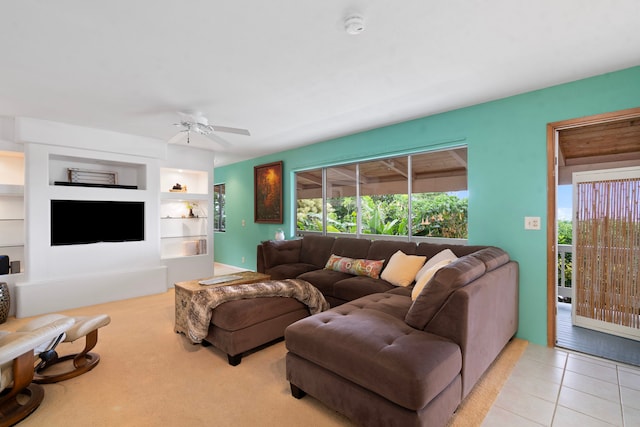 living area with built in shelves, tile patterned flooring, and a ceiling fan