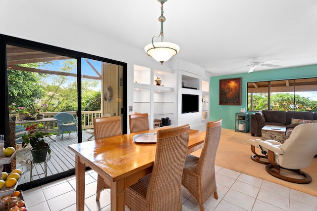 dining space featuring light tile patterned floors, ceiling fan, light colored carpet, and built in features