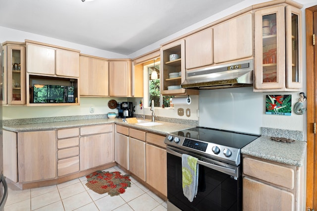 kitchen featuring light countertops, light brown cabinetry, a sink, under cabinet range hood, and stainless steel electric range