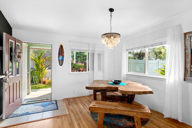 dining space featuring breakfast area, wood finished floors, and an inviting chandelier