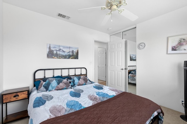 carpeted bedroom with a ceiling fan and visible vents