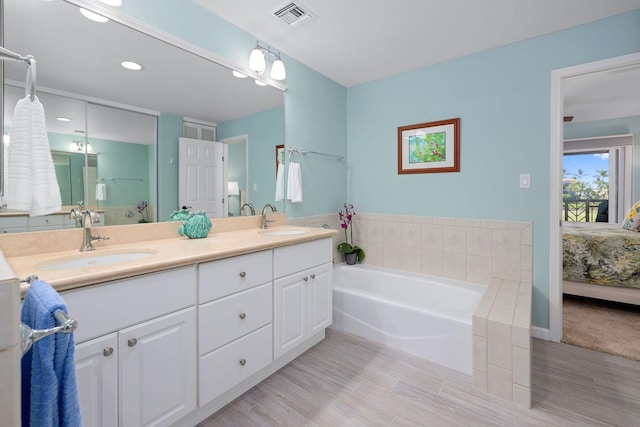 ensuite bathroom featuring ensuite bathroom, double vanity, a sink, and visible vents