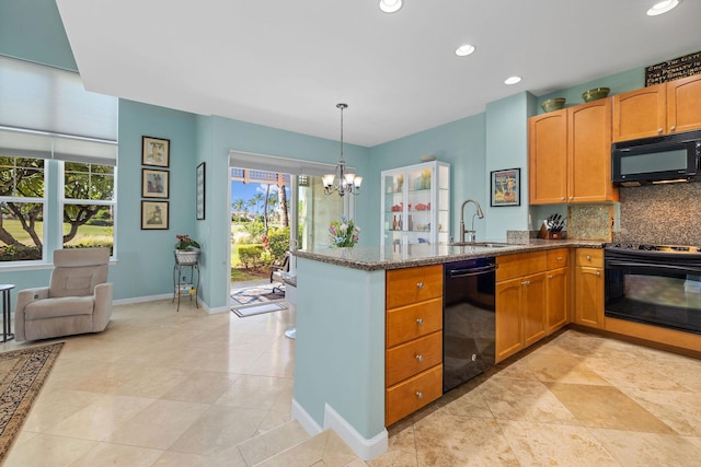 kitchen featuring light stone counters, decorative backsplash, an inviting chandelier, a sink, and black appliances