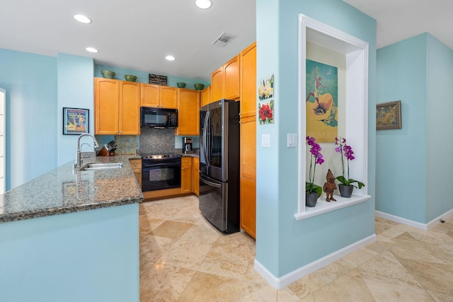 kitchen featuring decorative backsplash, stone counters, black appliances, a sink, and recessed lighting