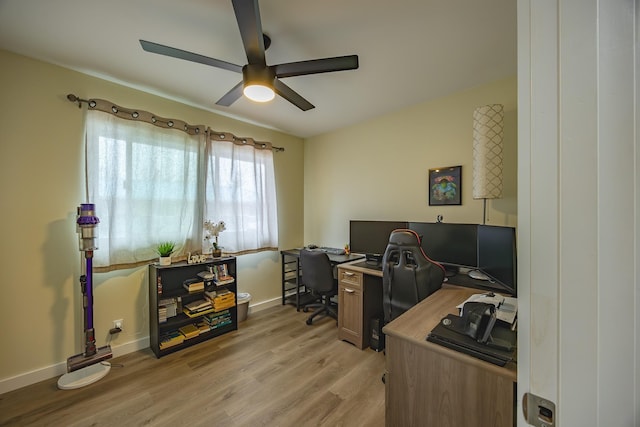 office featuring a ceiling fan, light wood-style floors, and baseboards