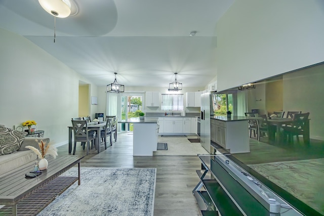 living area with an inviting chandelier, baseboards, and light wood-style floors