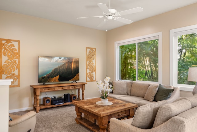 living area with ceiling fan, carpet, and baseboards