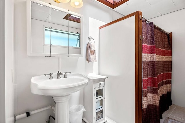 bathroom featuring curtained shower and tile patterned flooring