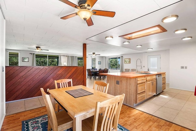 dining area with light wood finished floors and a skylight