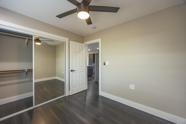 unfurnished bedroom with dark wood-style floors, a closet, ceiling fan, and baseboards