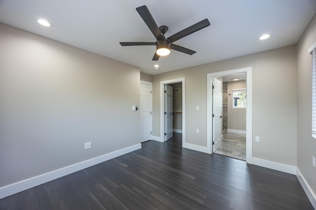 unfurnished bedroom featuring recessed lighting, dark wood-style flooring, a spacious closet, and baseboards